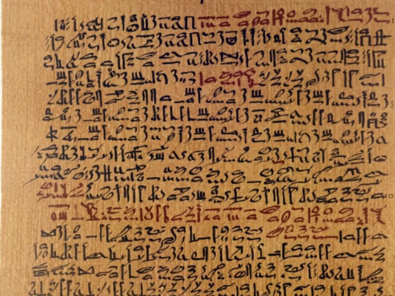 Ancient papyrus scroll resting on a stone surface, representing historical writing materials