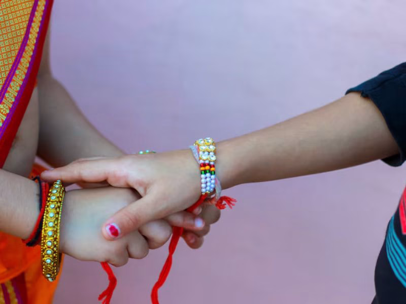 Brother and sister exchanging Raksha Bandhan wishes with smiles