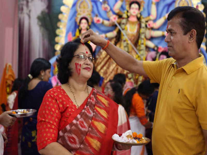 Husband giving Dussehra greeting and flowers to wife